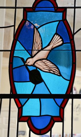 a stained glass window with a dove