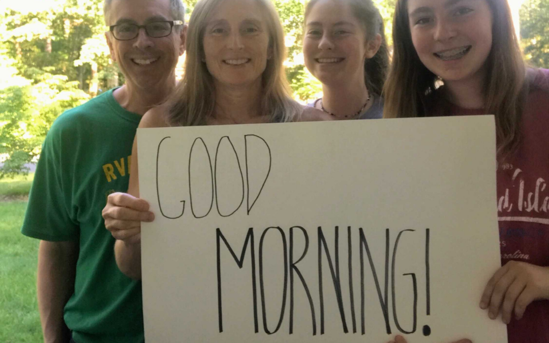 Family holding good morning sign.