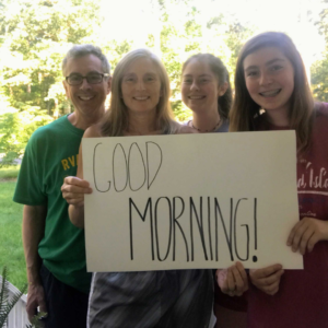 Family holding good morning sign.