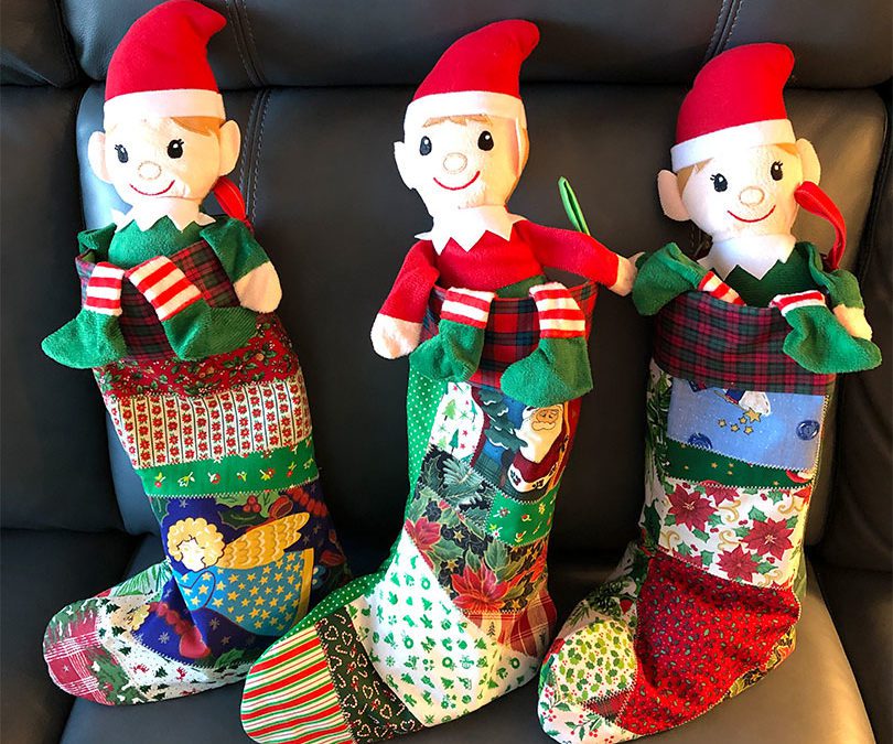three handmade stockings with elves inside