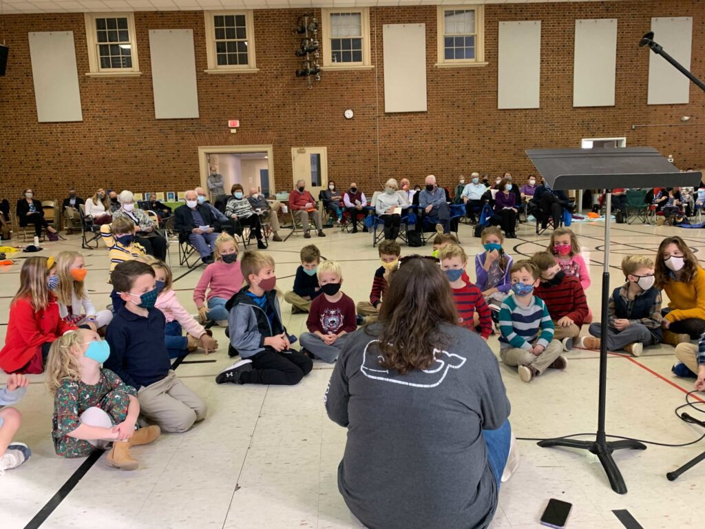 kids listening to a story at worship in a gym